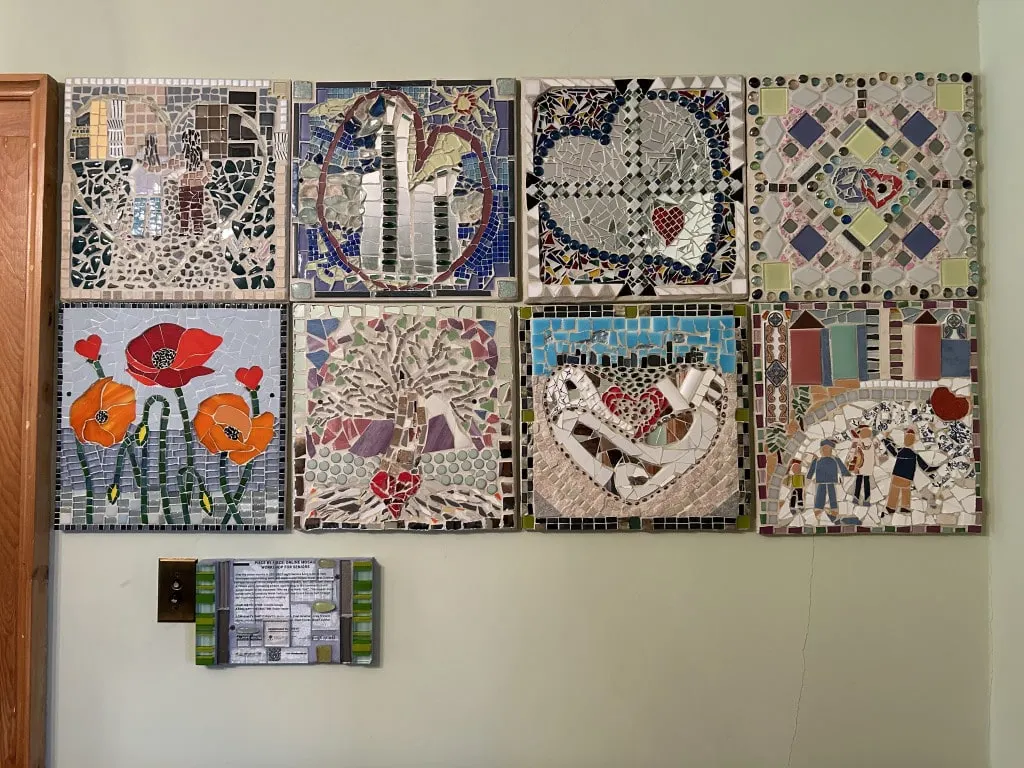Eight square mosaic pieces side-by-side mounted on a wall