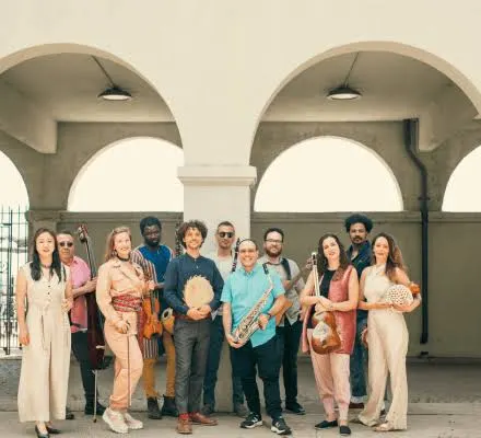 A group of musicians stand under an archway.