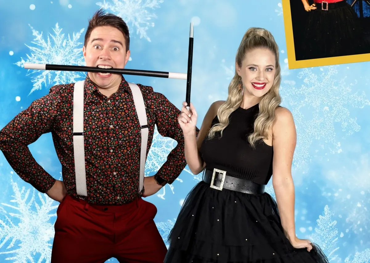 two people in magician clothing holding magic wand stick with a light blue christmas background